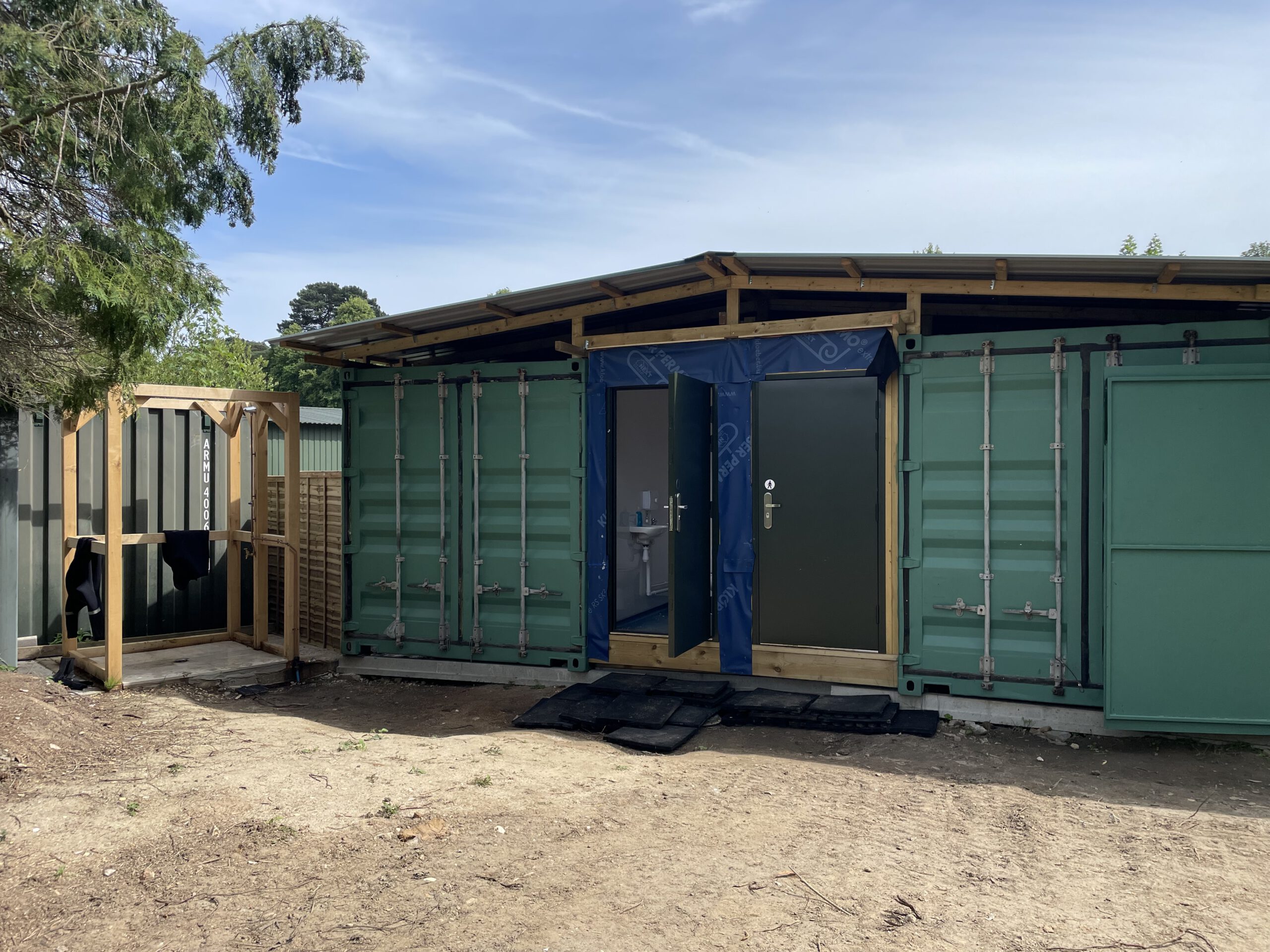 Shipping containers for shop and storage along with outdoor shower installation.